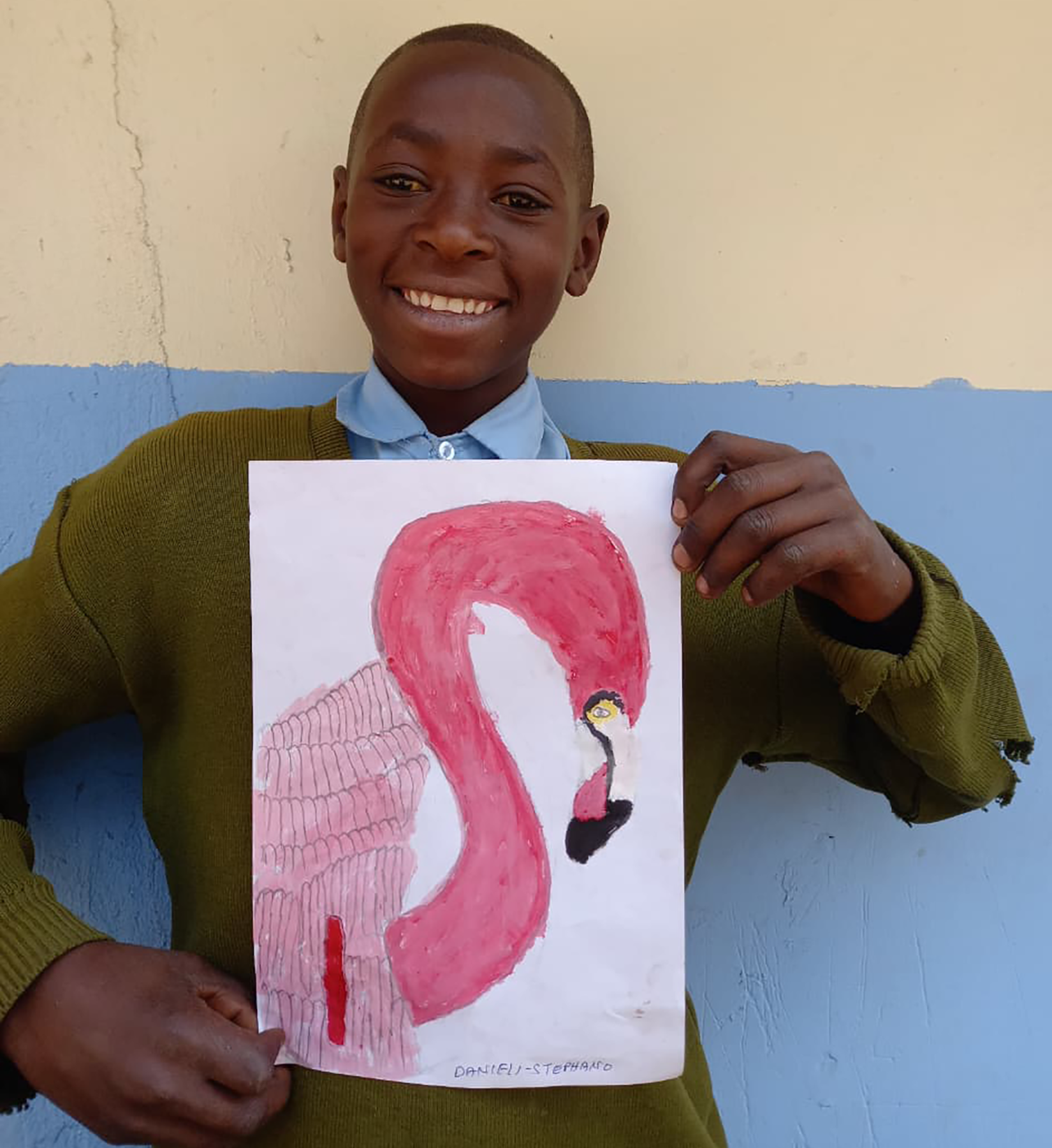 A girl proudly holds her flamingo painting