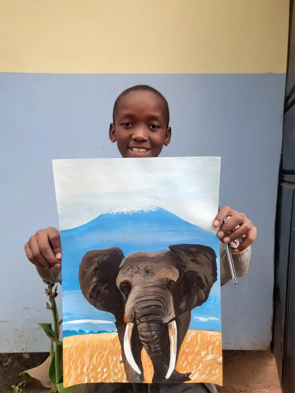 Ibrahimu Martin Daniel holding his original elephant and Kilimanjaro painting