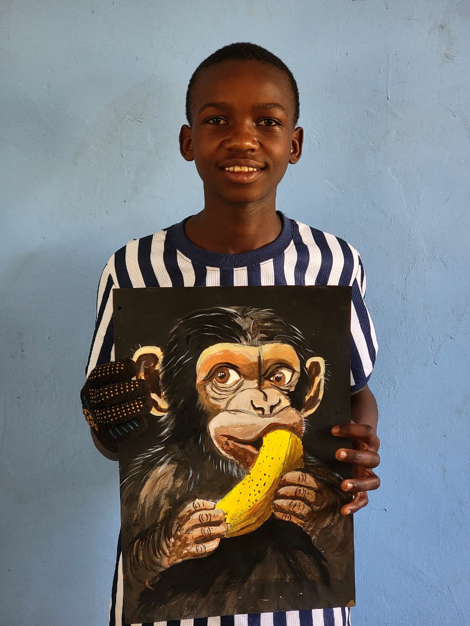 Shedrack Elikana holding his original chimpanzee painting